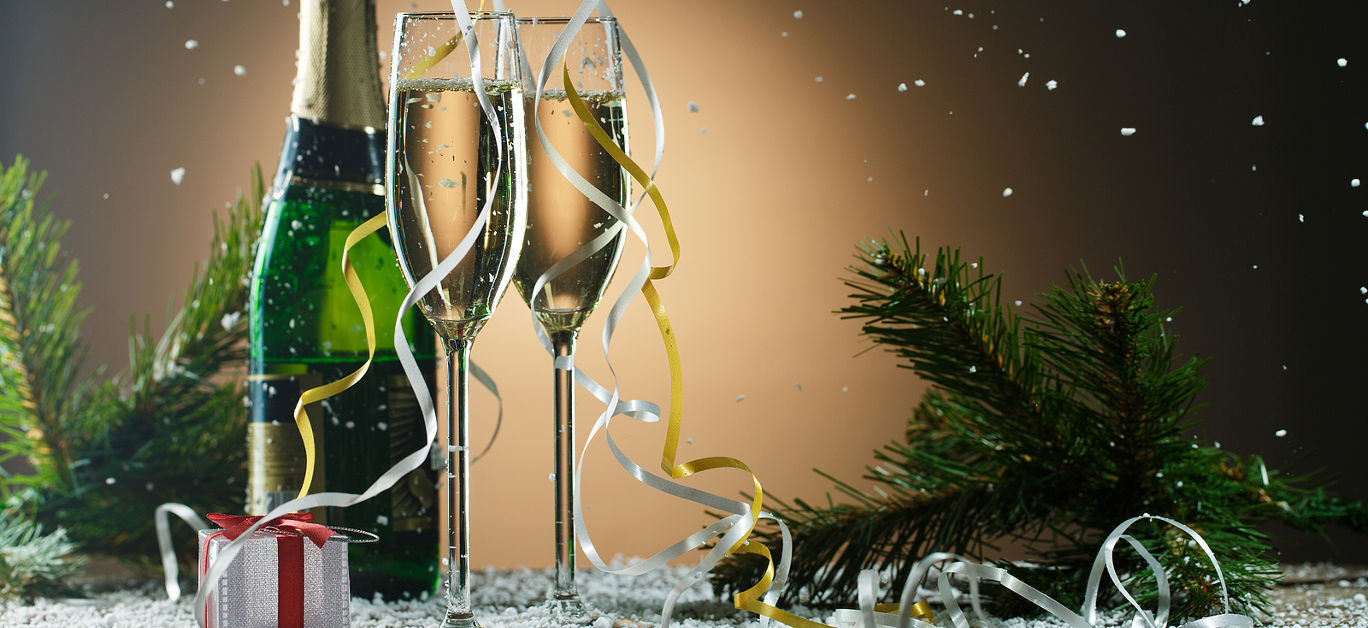 Festive Christmas composition with champagne glasses, gift and snow