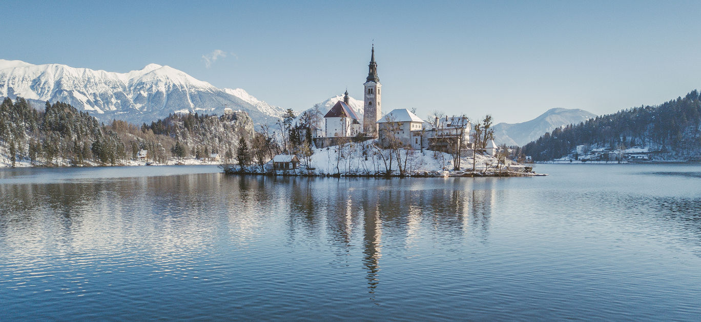 Lake Bled with Bled Castle (Blejski grad) and Julian Alps in the background on a beautiful sunny day in winter, Slovenia