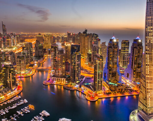 Dubai Marina at Blue hour, Glittering lights and tallest skyscrapers during a clear evening with Blue sky.