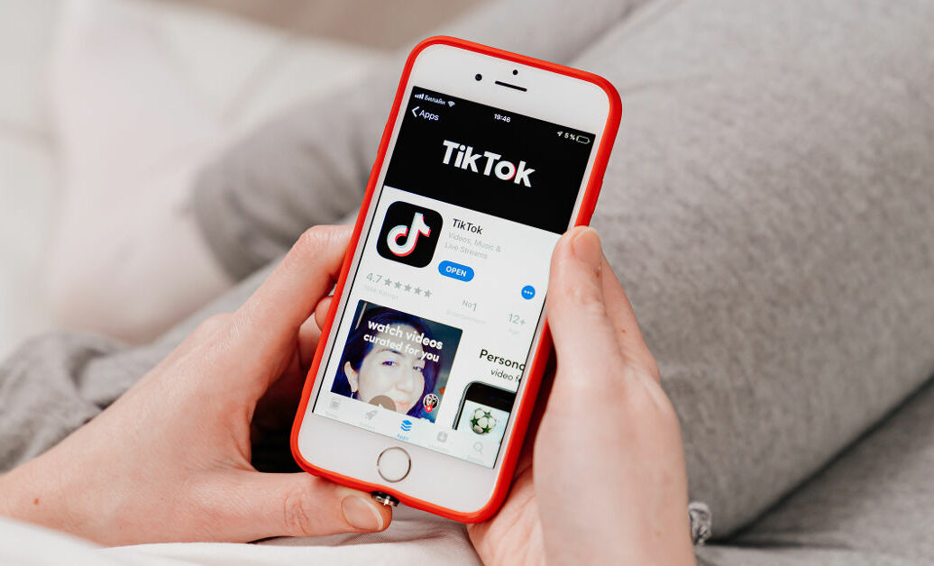 tiktok. iPhone in hand. installing app on a smartphone.