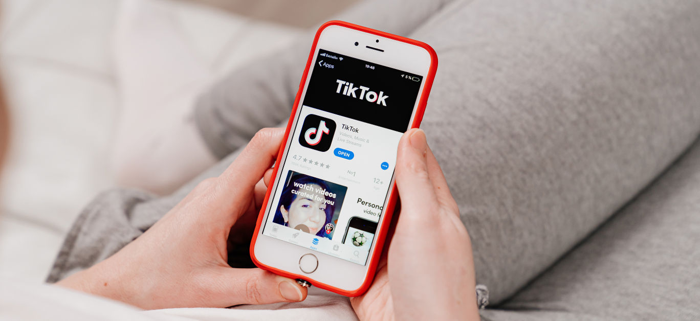 tiktok. iPhone in hand. installing app on a smartphone.