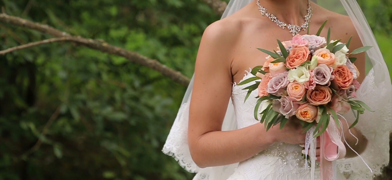 Bride with flowers in hand outdoors in summer or winter