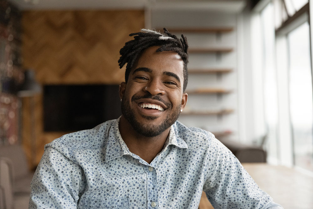 African stylish hipster guy with dreadlocks smile look at camera