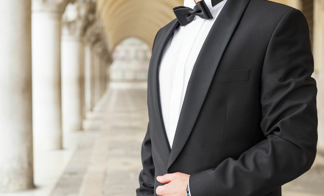 Elegantly dressed man in tuxedo standing outside