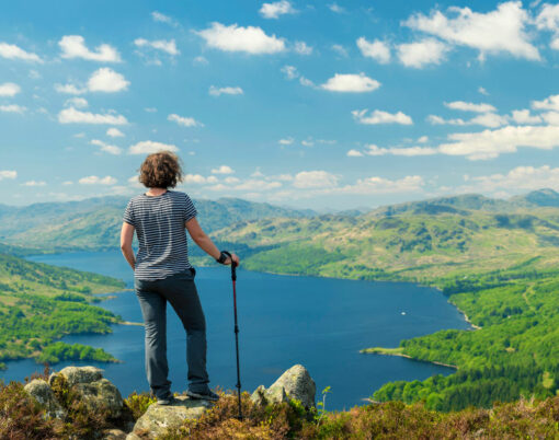 Hiking woman on top of the Mountain in Ben A'an Hill, Highlands, Scotland, Panoramic Shot - Panorama Of Landscape View From Ben A'an Hill, Highlands, Scotland