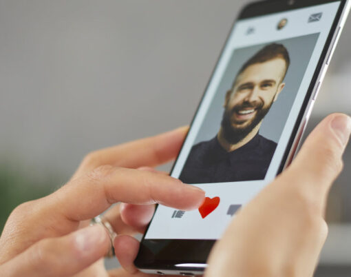 Woman holding mobile phone gives like to young man on online dating app or website