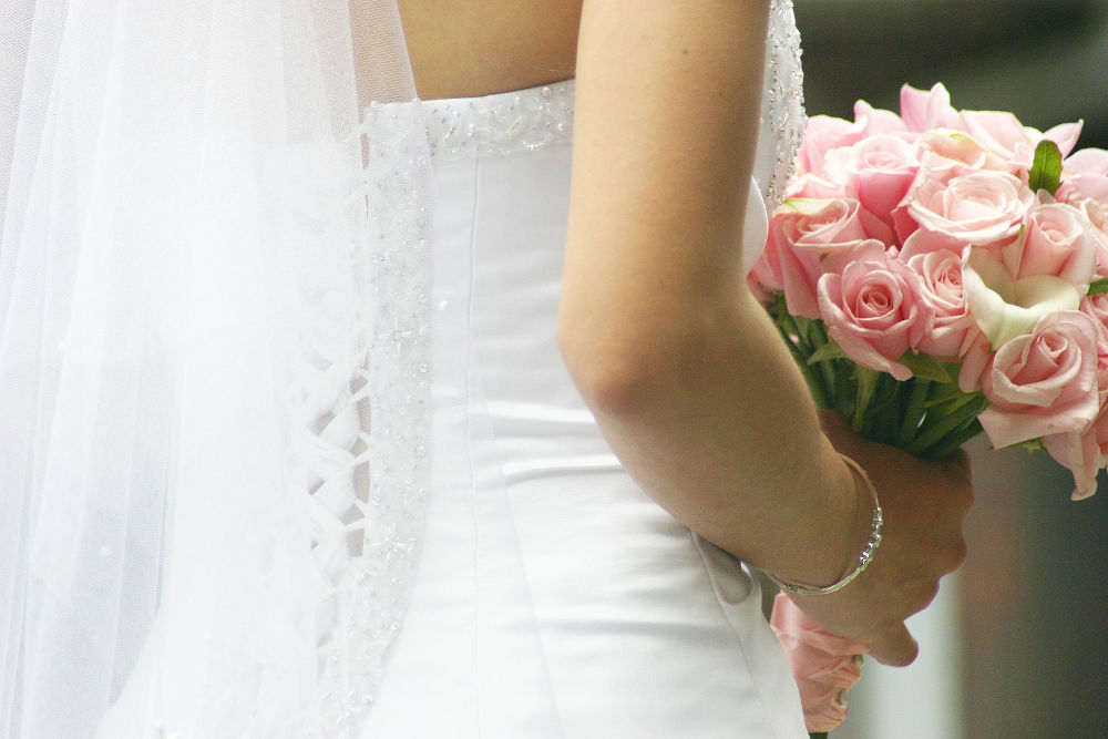 a classic bride poses with pink flowers